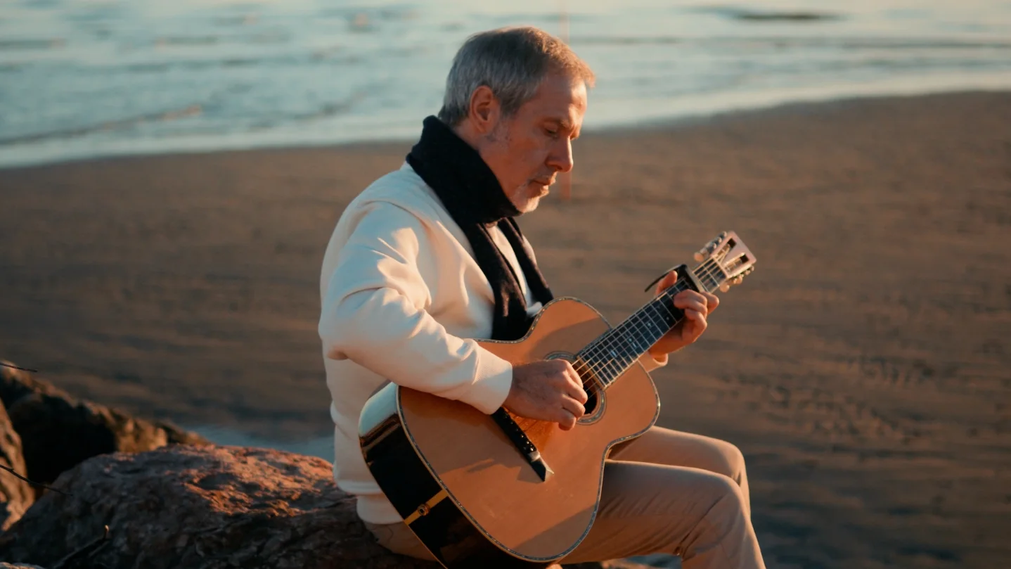 Il cantautore — chitarra sugli scogli